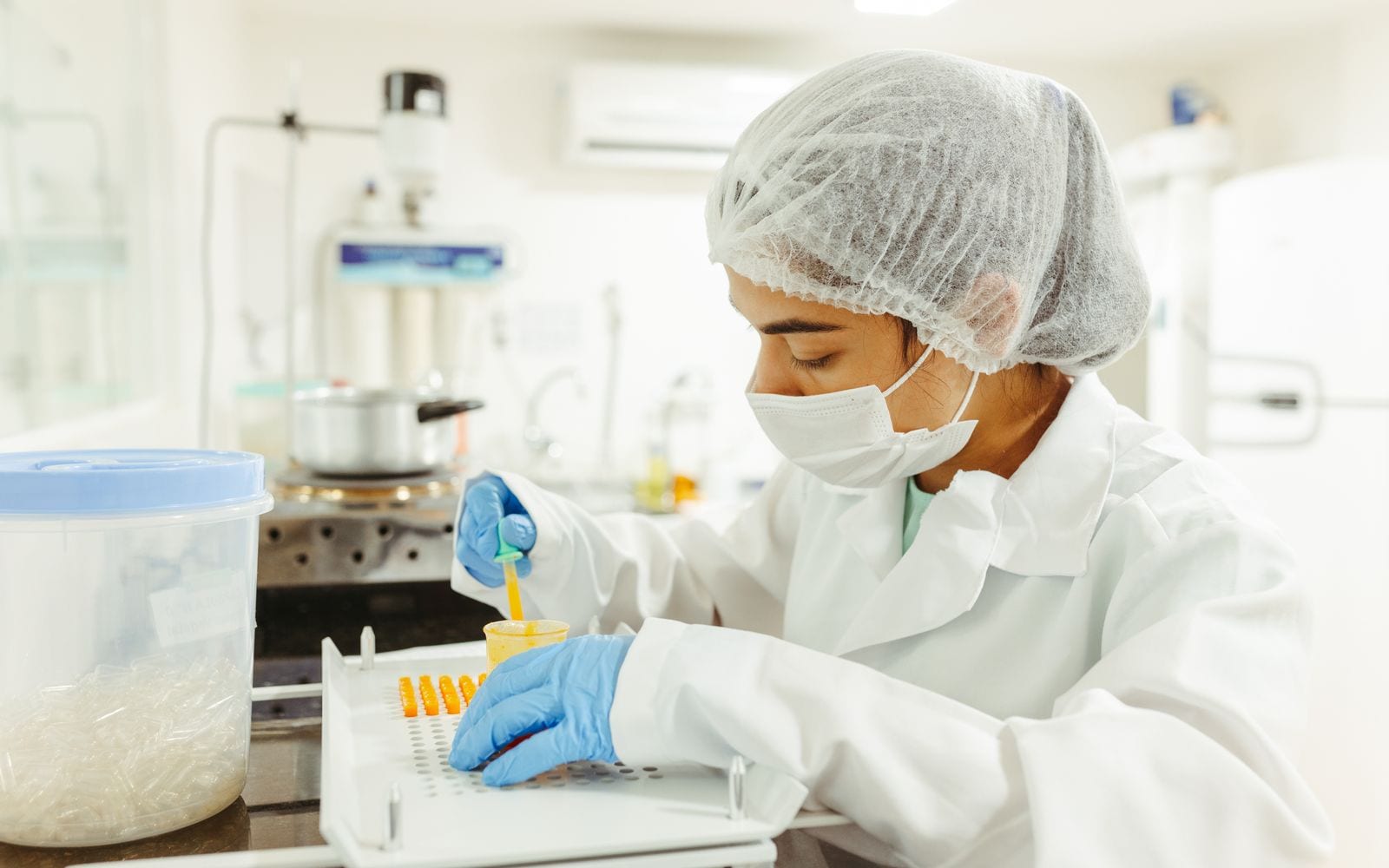 Una ricercatrice in camice prepara dei campioni in laboratorio